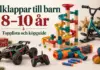 Julklappstips för barn 8–10 år med kulbana, snösparkcykel, radiostyrd bil, skumpilspistol och jongleringsbollar bland julklappar och granris.