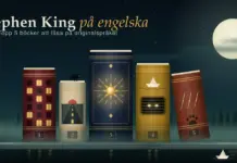 Stephen King på engelska – topp 5 böcker att läsa på originalspråket Illustration av fem numrerade böcker som står som husfasader i en dimmig småstad under fullmånen, med upplysta hotellfönster, en ensam väg, en gyllene talisman, en dagvattenbrunn med lysande ögon och klösmärken på bokryggarna, en pappersbåt som driver längs gatan och texten ”Stephen King på engelska – Topp 5 böcker att läsa på originalspråket”.